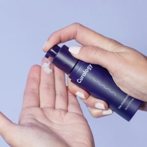 person holding Curology spray bottle